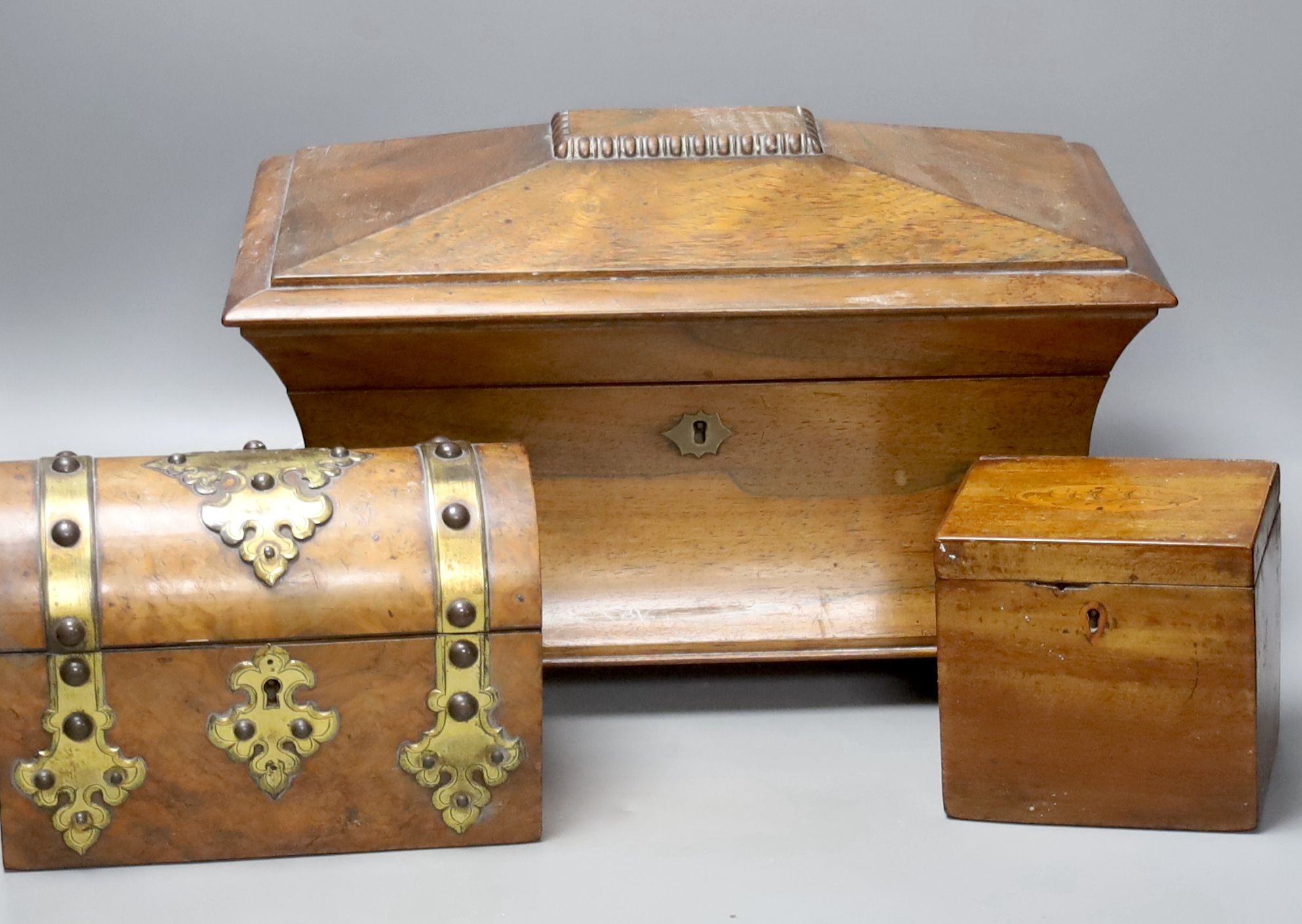 A Victorian rosewood sarcophagus tea caddy, 36.5 cm, a mahogany caddy and a Victorian Walnut and brass mounted casket